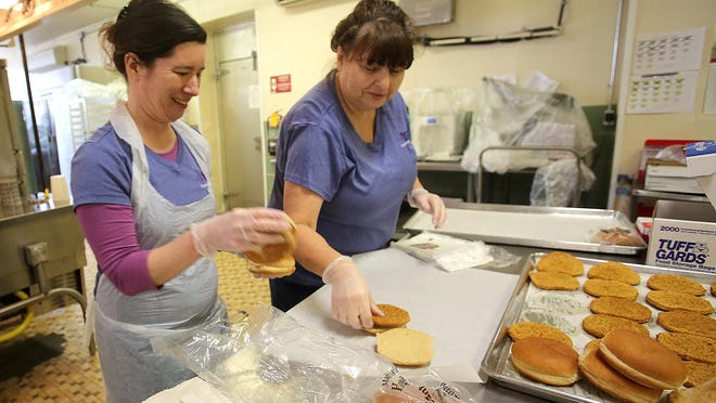 Cafeteria workers make school lunches for Cleveland County children.