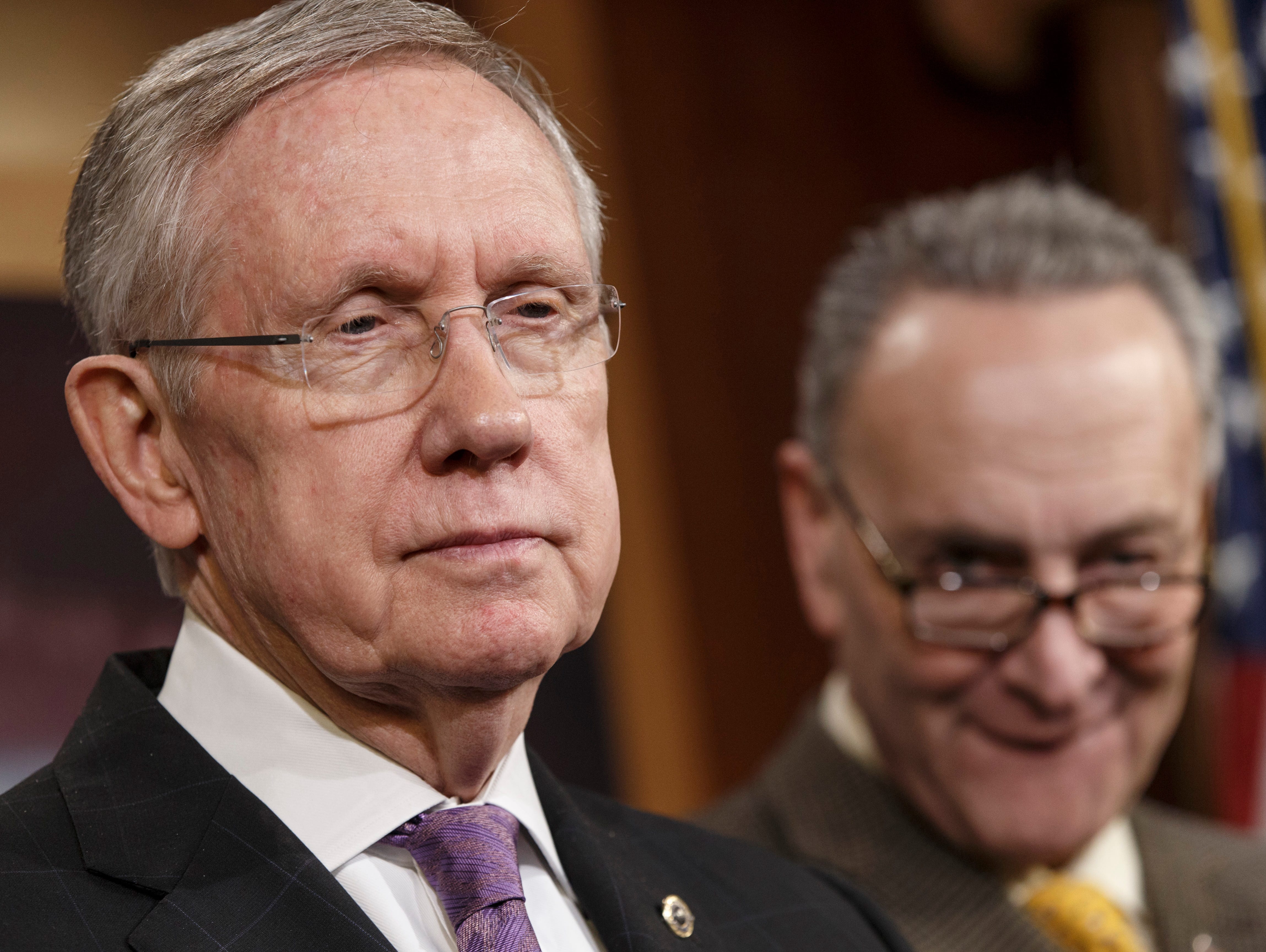 Senate Minority Leader Harry Reid, D-Nev., left, accompanied by Sen. Chuck Schumer, D-N.Y., listens during a news conference on Capitol Hill.
