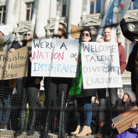 A crowd chants in front of a fence near Battery...