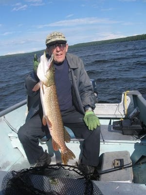 Roman Baumgart of Kenosha holding a heavy 35.5 inch northern pike taken on Portal Lake, Ontario, Canada.
