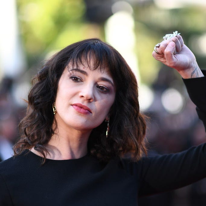Actress Asia Argento raises her fist as she arrives Saturday for the closing ceremony. She took the awards stage to give a blistering speech about Harvey Weinstein, the disgraced movie mogul she's accused of raping her at Cannes.