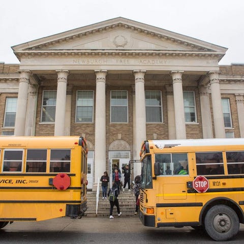 Students board buses in front of NFA