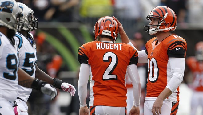 Cincinnati Bengals punter Kevin Huber (10) taps the helmet of  kicker Mike Nugent (2), after Nugent missed the possible game winning field goal against the Carolina Panthers during overtime of their game played at Paul Brown Stadium.
