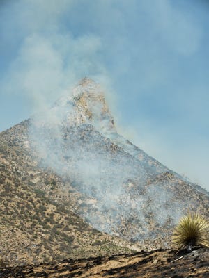 Smoke still rises Monday June 25, 2018 from a blaze started by a vehicle fire Sunday evening on Highway 70 near San Augustin Pass. Fire crews with county, BLM and White Sands Missile Range all responded to the fire, which they worked through the night.
