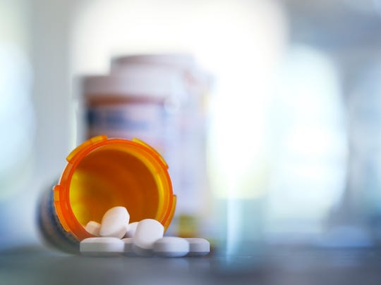 Pills pour out of a prescription medication bottle