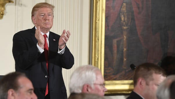President Trump claps before presenting the Medal of