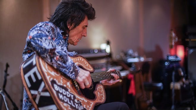 Ronnie Wood gets in some practice on a gift from the Buddy Holly Educational Foundation.