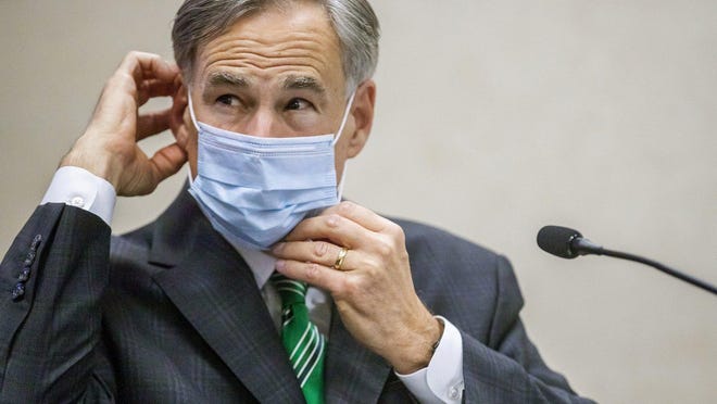 Texas Gov. Greg Abbott adjusts his mask after giving an update on coronavirus response at a press conference Tuesday.