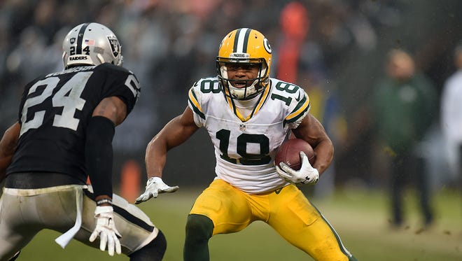 Green Bay Packers receiver Randall Cobb (18) tries to elude Oakland Raiders cornerback Charles Woodson (24) after making a catch in the fourth quarter at the O.co Coliseum.