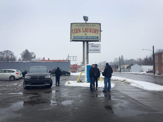 Members of Detroit Police Department's homicide unit stand in front of a Project Green Light partner as they investigate the death of Antonio Fountain, 58, on Jan. 10, 2018.