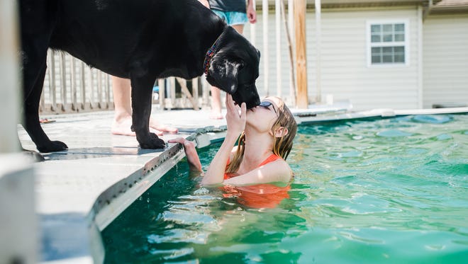 Emma Haines, 11, gives a kiss to her one year-old black Labrador, Abby, while staying cool with her family at their home in Conewago Township. Emma has a disorder known as PANDAS, a condition that stems from a strep throat infection and causes a wide degree of neuropsychiatric issues, among them being obsessive compulsive disorder and anxiety. Though Emma's parents, Jen and Reggie Haines, often find it hard to have Emma spend time in public because of anxiety attacks, Emma's favorite activities include spending time with her siblings and her dog, Abby.