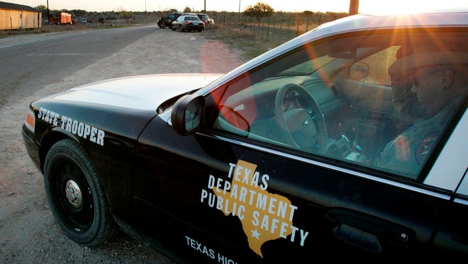 A Texas State Trooper sits in his vehicle in Eldorado, Texas.