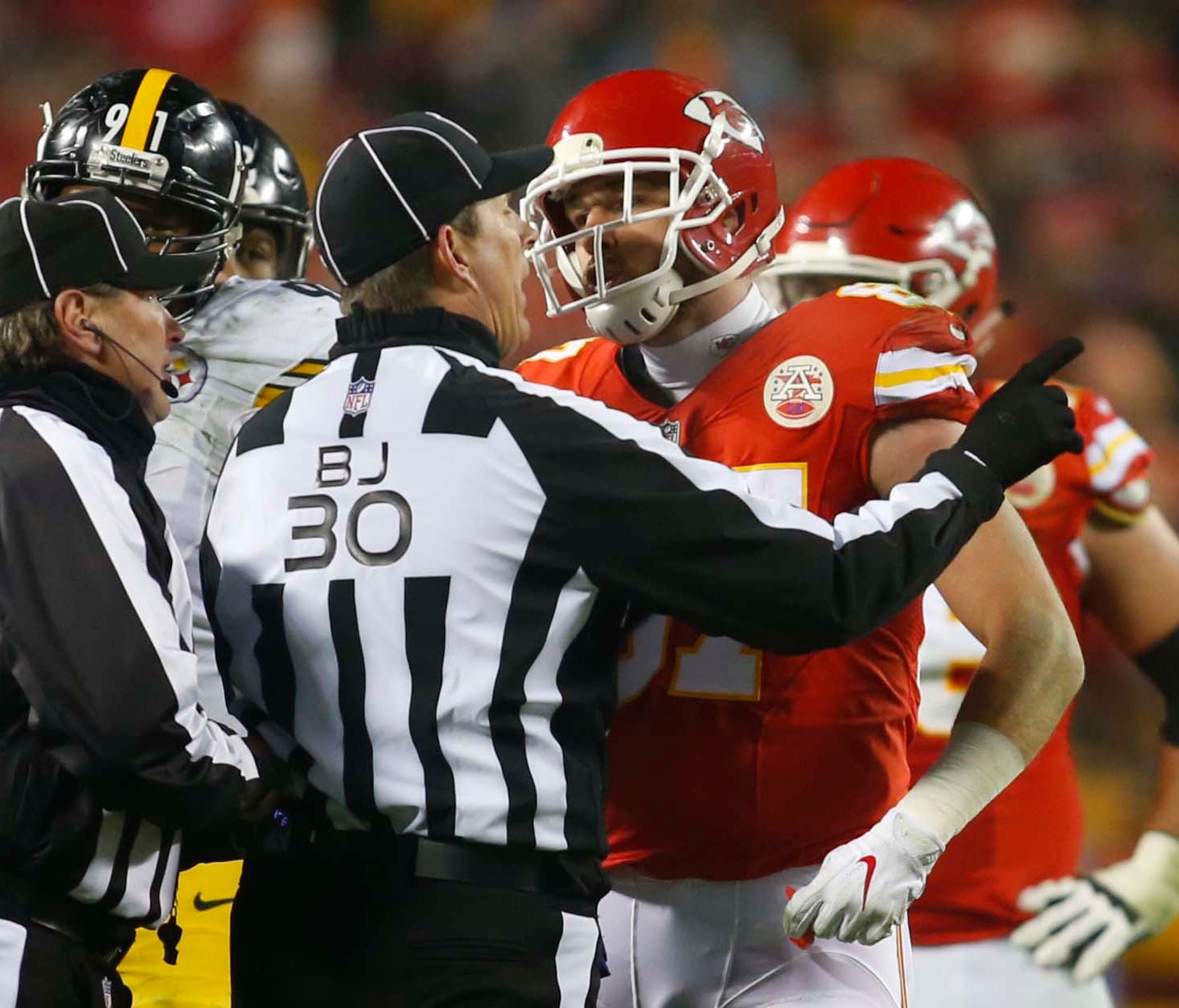 Kansas City Chiefs tight end Travis Kelce (87) is held back by back judge Todd Prukop (30) as he speaks to field judge Doug Rosenbaum (67) during the third quarter against the Pittsburgh Steelers in the AFC Divisional playoff game at Arrowhead Stadiu