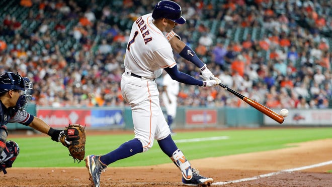 Houston Astros' Carlos Correa (1) hits a two-run double as Atlanta Braves catcher Kurt Suzuki works behind the plate during the fifth inning of a baseball game Wednesday.