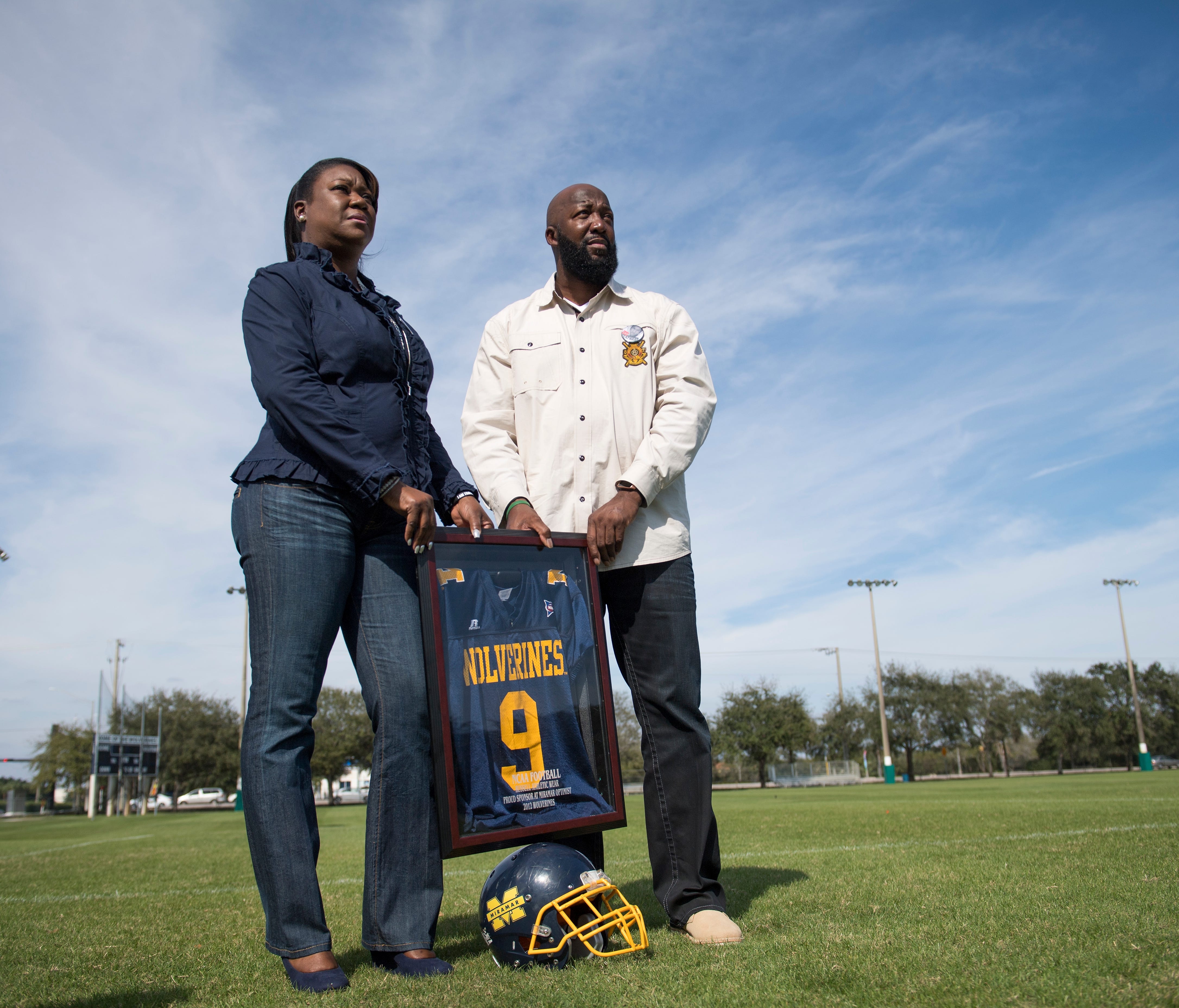 Trayvon Martin's parents,  Tracy Martin and Sybrina Fulton, pose on the Forzano Park football field where their son played youth football.
