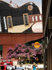 A tourist takes a photo of the Hard Rock Cafe on Lower