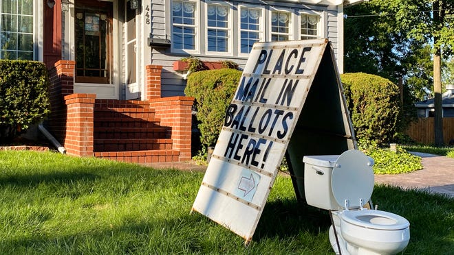 A political display is set up in the lawn of a home on West Columbia Street in Mason, Mich., on Friday, Sept. 18, 2020.  Barb Byrum, the Democratic clerk of Ingham County, filed a complaint with police over the display, saying it could mislead people who aren't familiar with how mail-in voting works.