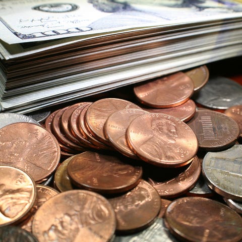 A stack of $100 bills on a cluster of coins