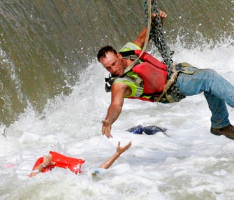 Jason Oglesbee, a construction worker who was working on a nearby project, helps pull Patricia Ralph-Neely from the Des Moines River near the Center Street Dam. He is hanging from a chain that is hooked to a construction crane.