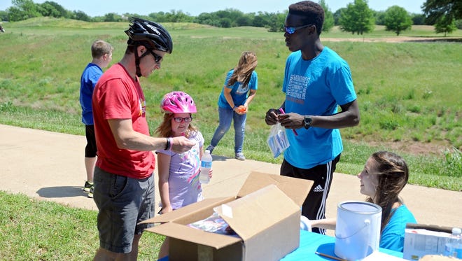 Chad Schroeder (left) and his daughter, Posie, talk with Eugene Wanyama and Lera Kuzhim (right) at a "cheer stop" along the Circle Trail near Weeks Park Lane in 2015. The Circle Trail Tour returns from 10 a.m. to 2 p.m. April 29.