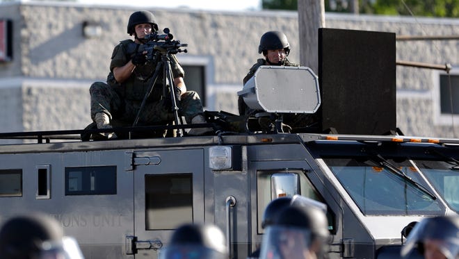 A police tactical team moves in to disperse a group of protesters in Ferguson, Mo. on Aug, 9, 2014, that was sparked by the shooting of Michael Brown.