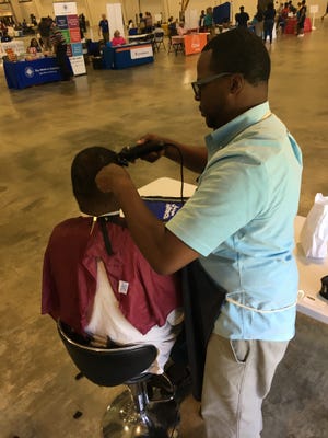 Ron Baker of Chop Shop at 1 Court Square provides a haircut at the River Region Connects Homeless Resource Fair at the Multiplex at Cramton Bowl on July 14, 2016.