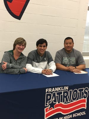 Livonia Franklin senior Nathan Atienza celebrates signing to wrestle at Michigan State University with parents Susan and Armand.