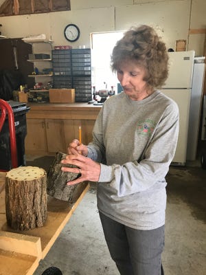 Brighton Garden Club member Cheryl Yelen marks where the holes will go in a mason bee house, in this submitted photo from May 2017. The club is selling the bee houses at its annual plant sale Saturday.