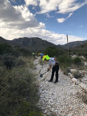 Students who are volunteering with the Student Conservation Association work on trails at Carlsbad Caverns National Park.