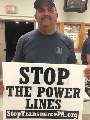 Jan Horst, a Marion farmer, picked up a sign after and informational meeting about the Transource power line on Wednesday, Sept. 19, 2017.