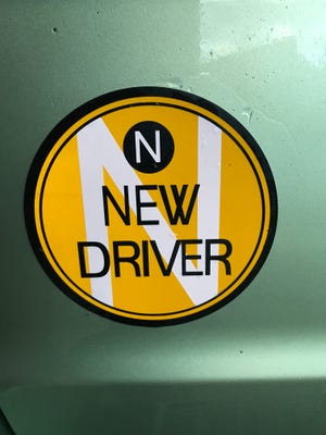 An “N” now marks the rear of Bruce Dorries' car. Not a scarlet letter, but a school-bus-orange-black-and-white badge. The six-inch circular magnet signals “New Driver. ”