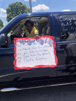 Doris Borders holds up a poster she made to celebrate Pastor Melvin Clark's 11 years with Washington Missionary Baptist Church. Church members held a parade that went past Clark's house Sunday afternoon.