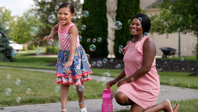 Nikeytha Ramsey laughs as her daughter Journee, 5, chases soap bubbles from a bubble machine Wednesday, June 13, 2018, in the back yard of their West Lafayette home. Journee suffers from epileptic seizures. However, since beginning a classic strict medical ketogenic diet, the youngster has been seizure free for the past 15 months. 