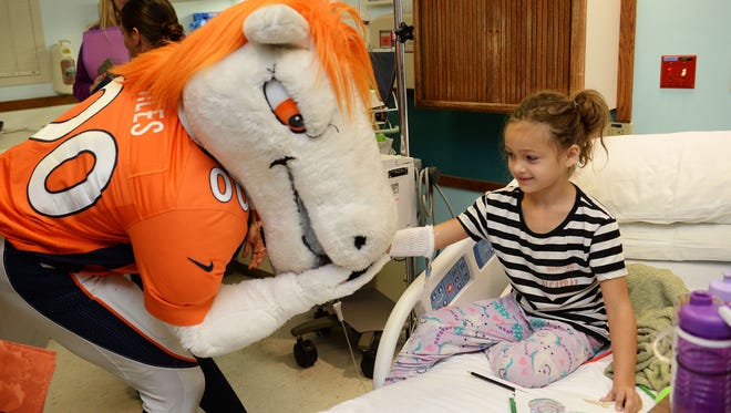 The Denver Broncos mascot, Miles, kisses the hand of Kaydence Blunck, 6, at Poudre Valley Hospital on Wednesday, November 16, 2016. Miles and two cheerleaders visited patients to spread good cheer. 