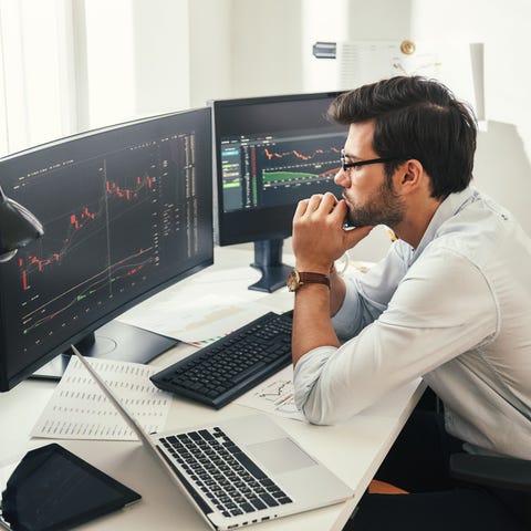 Investor sitting in front of computer with stock c