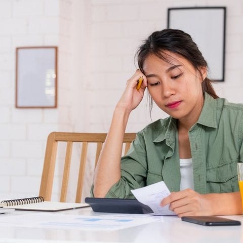 A stressed woman sitting at her dining table and l