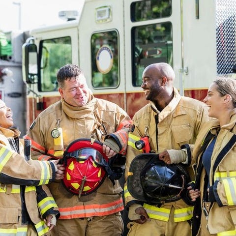Four firefighters talking and laughing in their ge