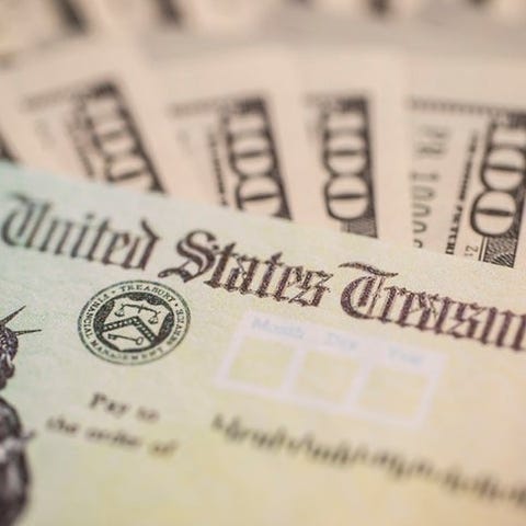 $100 bills surround a stimulus check from the U.S.