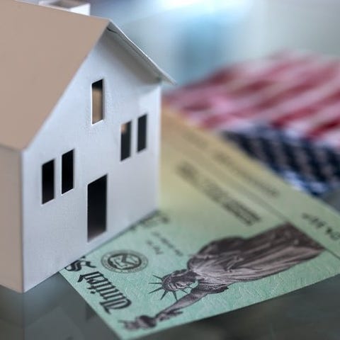 A white cardboard house sits on top of a stimulus 