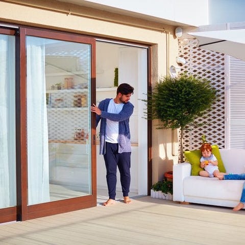 A dad opening a glass sliding door to check on his