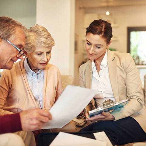 A mature couple discusses paperwork with a busines