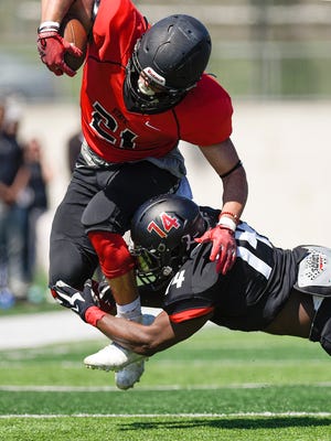 St. Cloud State's Joe Blando is brought down by Jamari Manuel on a run during the first half of the Spring Showcase Saturday, April 22, at Husky Stadium.