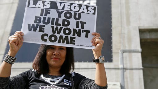 Monette Bonilla, of San Jose, Calif., holds up a sign outside the Oakland Coliseum before the start of a rally to keep the Oakland Raiders from moving Saturday, March 25, 2017, in Oakland, Calif.