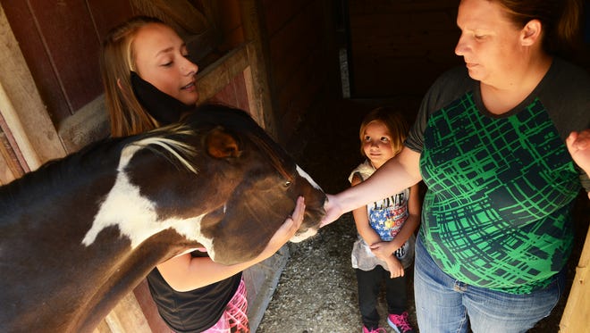 Sarah Courtney, left, and he mother Charlotte Rose rub the face of Magic in her stall at Shannon Lindsey's farm near New Church on Wednesday, Sept. 7, 2016. Magic injured all four of her legs recently. Courtney and her mother are tending to the wounds and hoping they can nurse the horse back to being healthy enough to show again.