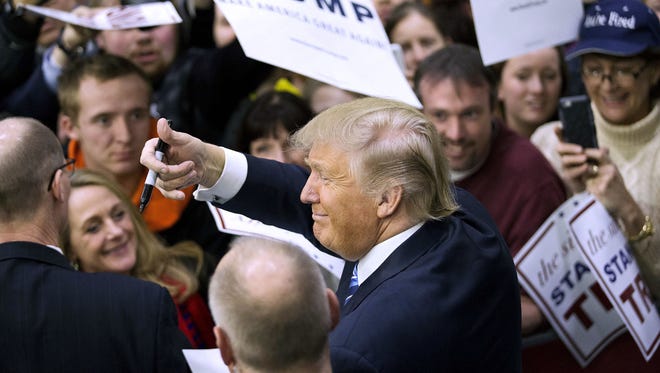 President-elect Donald Trump gestures to the crowd as he signs autographs in February 2016 during a campaign event at Plymouth State University in Plymouth, N.H.