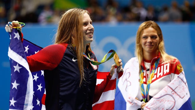 Gold medalist Lilly King of the United States celebrates as silver medalist Yulia Efimova of Russia looks on during the medal ceremony for the Women's 100m Breaststroke Final on Day 3 of the Rio 2016 Olympic Games at the Olympic Aquatics Stadium on August 8, 2016 in Rio de Janeiro, Brazil.
