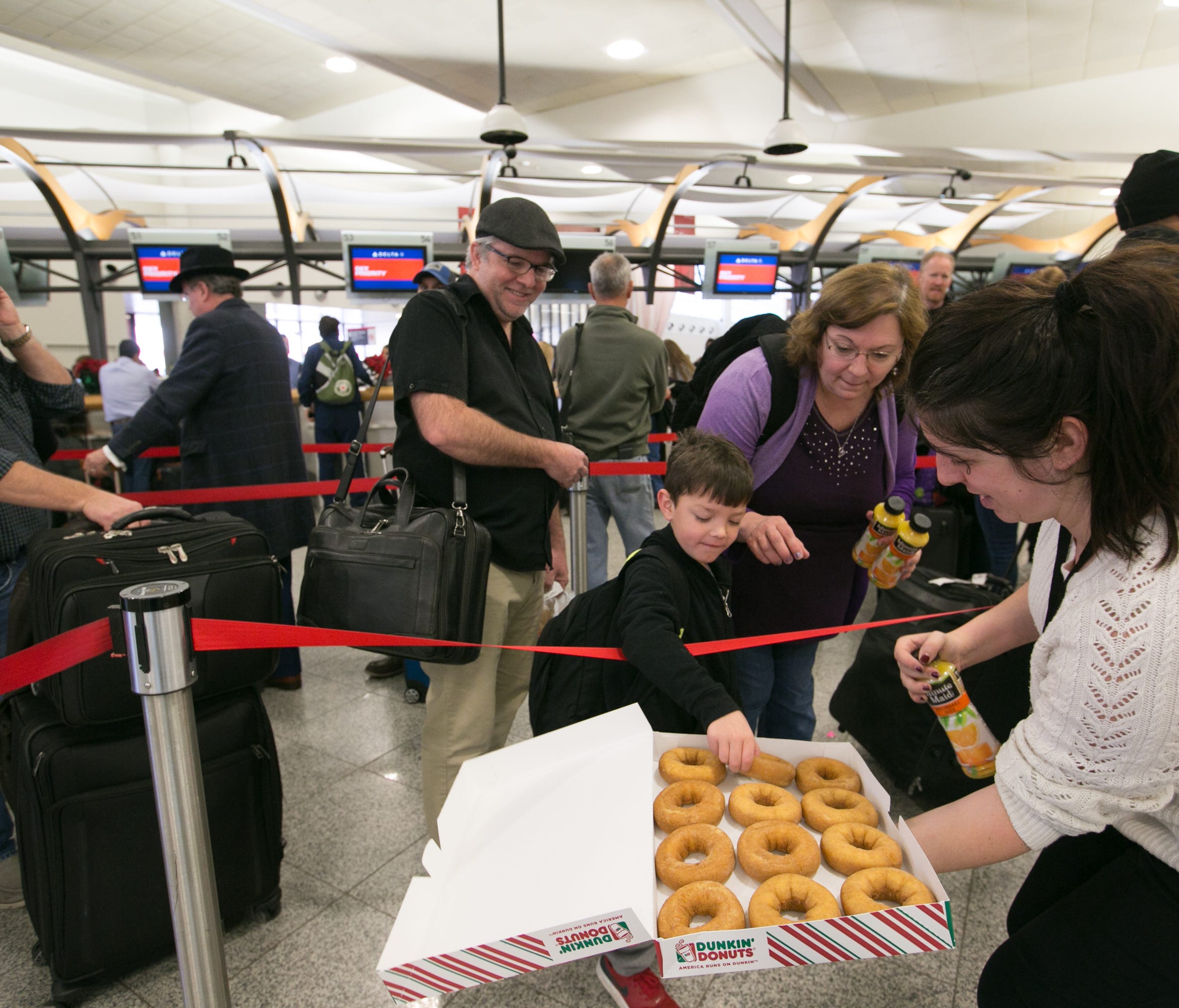 A Delta employee passes out doughnuts and juice to passengers at Hartsfield-Jackson Atlanta International Airport on Dec. 18, 2017. Hundreds of flights were cancelled after a power outage at the airport.
