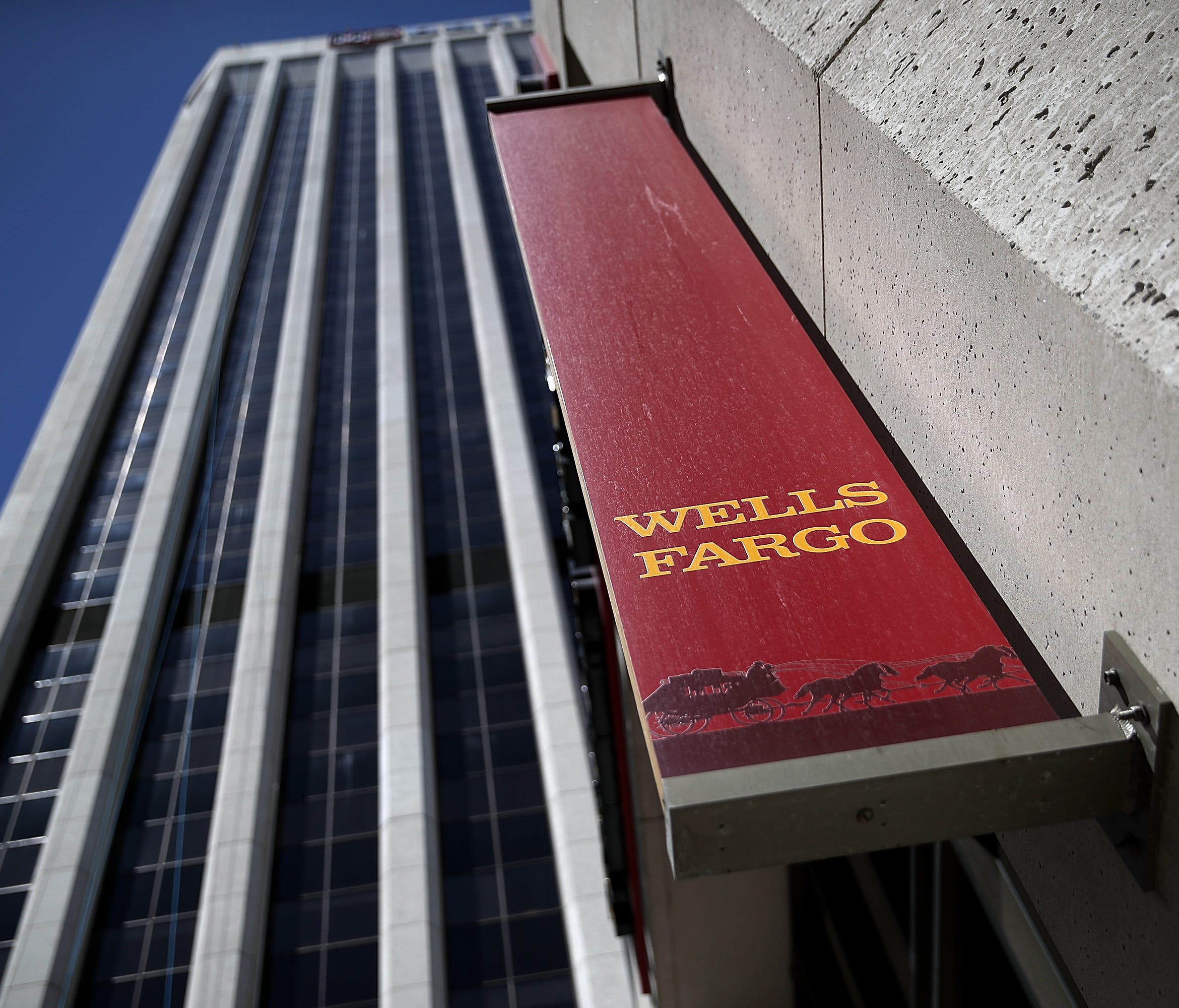 This file photo taken in 2017 shows a Wells Fargo sign at one of the bank's branch offices in San Francisco.