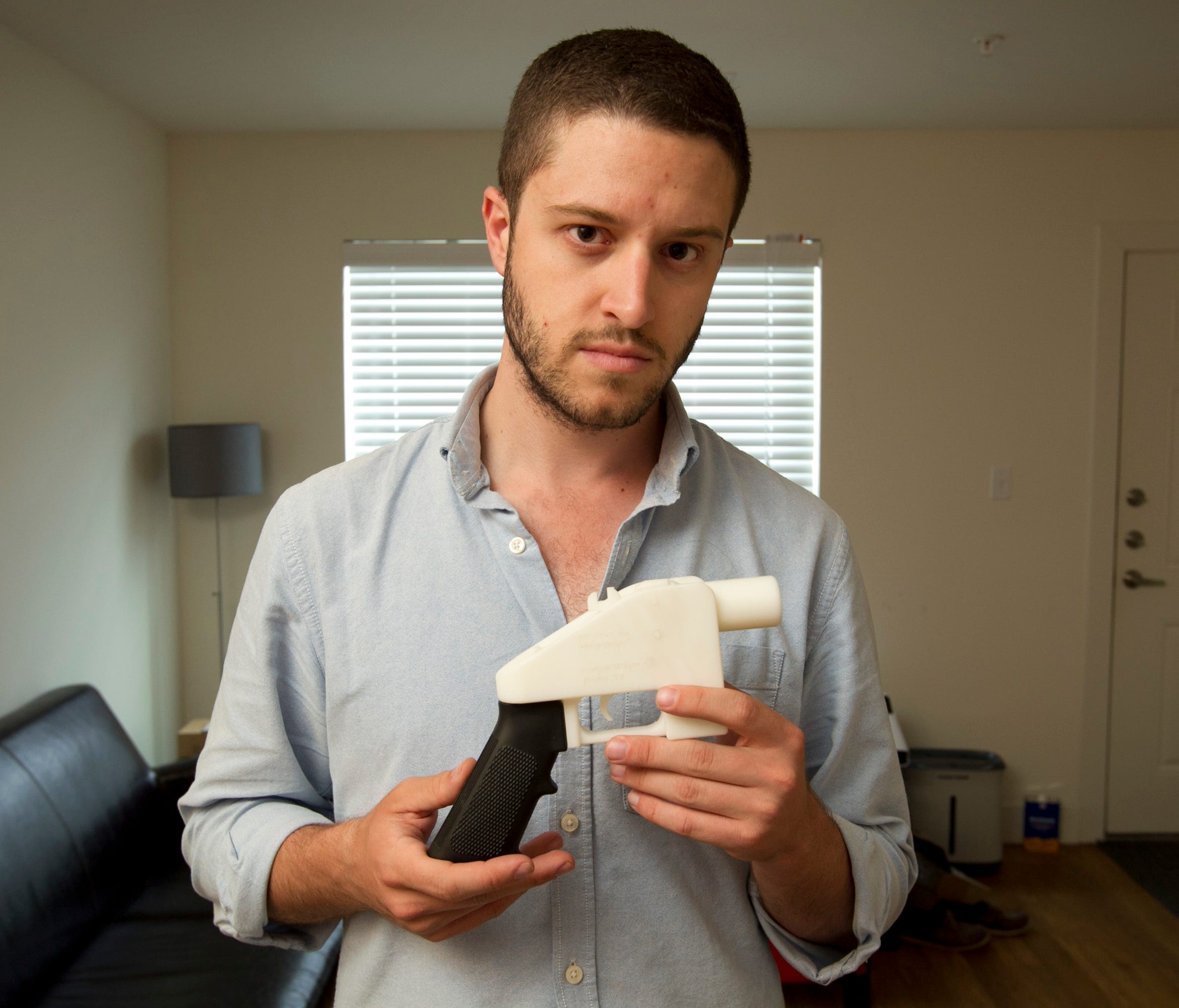 Cody Wilson, the founder of Defense Distributed, shows a plastic handgun made on a 3D printer at his home in Austin, Texas.