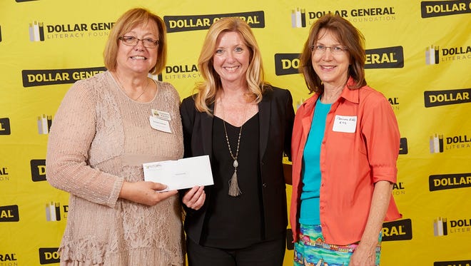 Carolynn Kobiske, left, and Mariana Eddy, right, receive $30,000 in grant money from Denine Torr, director of the Dollar General Literacy Foundation.